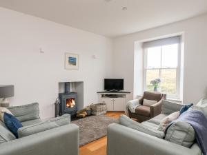 a living room with two couches and a fireplace at The Upper Deck in Penzance