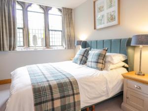 um quarto com uma cama e duas janelas em Apartment 1 St Mary's Church em Moffat