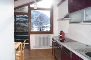 a kitchen with a stove top oven next to a window at Apartment Alpenpanorama in Goldegg