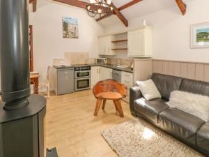 a living room with a couch and a kitchen at The Barn at Waunlippa in Narberth