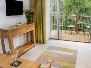 een woonkamer met een televisie en een balkon bij Gilson in Ambleside