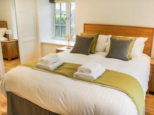 een slaapkamer met een groot wit bed en handdoeken bij Gilson in Ambleside
