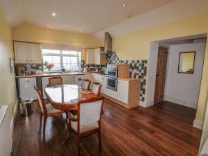 a kitchen with a table and chairs in a room at The Old Farm Cottage in Louth