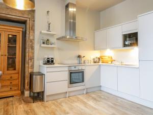 a kitchen with white appliances and wooden floors at Duplex in Moffat