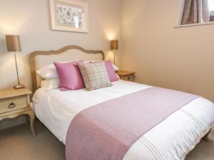 a bedroom with a bed with pink and purple pillows at Duplex in Moffat