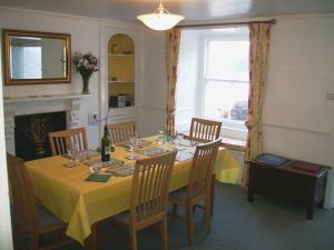 een eetkamer met een tafel met een geel tafelkleed bij Balcony Cottage in Cawsand