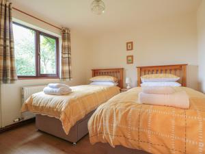 Duas camas sentadas uma ao lado da outra num quarto em Berrys Place Farm Cottage em Gloucester