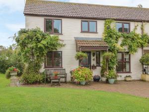a house with a bench in the front yard at Berrys Place Farm Cottage in Gloucester
