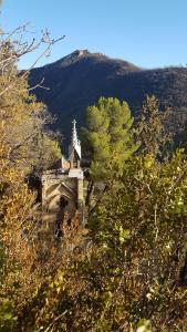 ディーニュ・レ・バンにあるLa Provence vous Attend - 2ème étageの手前に木々が植えられた丘の上の建物