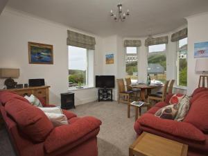 a living room with two red couches and a table at Cove View in Kingsbridge