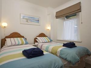 twee bedden in een kamer met handdoeken erop bij Cove View in Kingsbridge