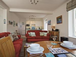 a living room with a table and a red couch at Cove View in Kingsbridge