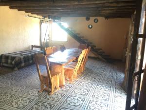 a dining room with a wooden table and a staircase at CABAÑA EN TANTI in Tanti +17 photos