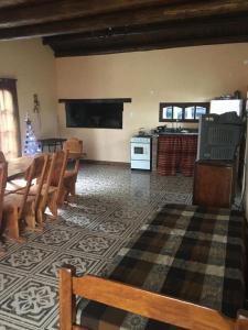 a living room with wooden chairs and a kitchen at CABAÑA EN TANTI in Tanti