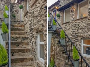 柯比朗斯代爾的住宿－The Landings，楼梯上种有盆栽植物的石头房子