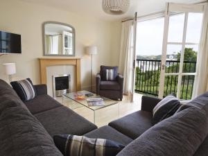 een woonkamer met een bank en een tafel bij 6 Combehaven in Salcombe
