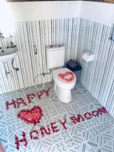 a bathroom with a toilet with red flowers on the floor at Pondok Bamboo Villa in Nusa Penida +32 photos