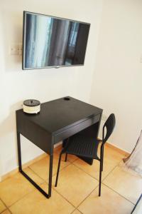 a black desk with a chair and a mirror at Raise Cosy Studio with pool in Limassol in Limassol