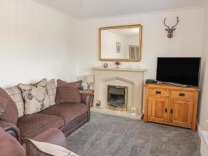 a living room with a couch and a tv and a fireplace at The Nook in Colwyn Bay