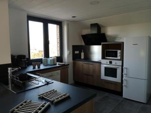 eine Küche mit einem weißen Kühlschrank und einer Arbeitsplatte in der Unterkunft Le Clos de Ramousies in Ramousies