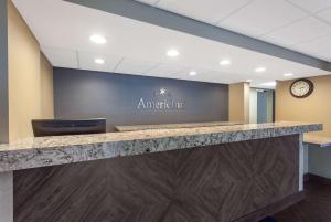 an office lobby with a stone counter and a sign that reads ampatient at AmericInn by Wyndham Mankato Event Center near MSU in Mankato