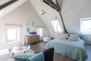 a attic bedroom with a bed and a couch at La Bourgeoise in Portbail