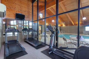 a gym with several treadmills and a swimming pool at AmericInn by Wyndham Mankato Event Center near MSU in Mankato