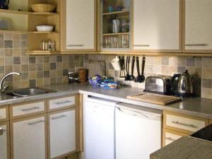 a kitchen with white cabinets and a counter top at Bridle Cottage in Settle