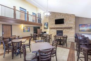 a restaurant with tables and chairs and a fireplace at AmericInn by Wyndham Mankato Event Center near MSU in Mankato