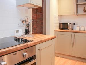a kitchen with a stove and a microwave at Pinner's Cottage in Knighton