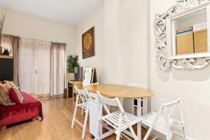 a living room with a table and chairs at Spacious 3 Bed Flat with Balcony in Kensington for 6 people in London