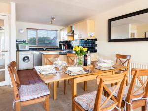 a kitchen and dining room with a wooden table and chairs at 164 Cumber Close in Kingsbridge +14 photos