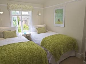 two beds in a room with a window at St Leonards in Salcombe