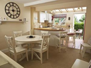 a kitchen and dining room with a table and chairs at St Leonards in Salcombe