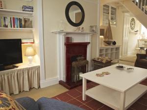 a living room with a white table and a fireplace at St Leonards in Salcombe