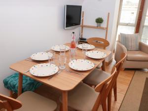 a dining room table with plates and glasses on it at 5 Harbour Yard in Salcombe