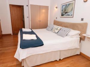 a bedroom with a large white bed with two pillows at 5 Harbour Yard in Salcombe