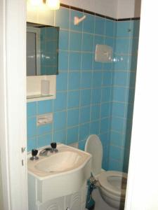 Baño azul con lavabo y aseo en Departamento 2 ambientes Miramar en Miramar