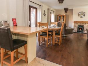 eine Küche und ein Esszimmer mit einem Holztisch und Stühlen in der Unterkunft Pebble Cottage Dunnscroft in Bridlington