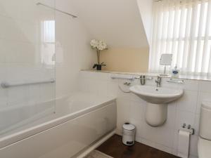 ein weißes Badezimmer mit Waschbecken und Badewanne in der Unterkunft Pebble Cottage Dunnscroft in Bridlington + 14 Fotos