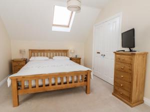 ein Schlafzimmer mit einem Bett und einem Fernseher auf einer Kommode in der Unterkunft Pebble Cottage Dunnscroft in Bridlington