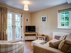 a living room with a couch and a tv at Cider Press in Burford