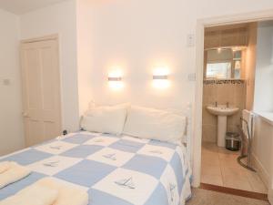 Un dormitorio con una cama azul y blanca y un lavabo en 5 Island Street en Salcombe