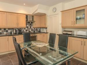 a kitchen with a glass table and chairs at 5 Island Street in Salcombe