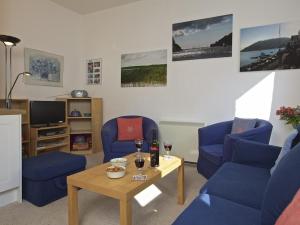 ein Wohnzimmer mit 2 blauen Stühlen und einem Tisch in der Unterkunft Columbine in Dartmouth