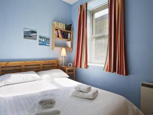 um quarto azul com uma cama com toalhas em Columbine em Dartmouth