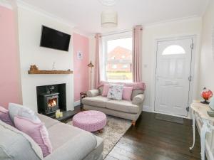 a living room with a couch and a fireplace at Coorie Cottage in Great Yarmouth