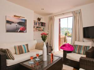 a living room with a couch and a table with wine glasses at The Cottage, 13 Clarence Hill in Dartmouth