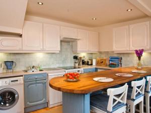 a kitchen with a wooden island with a dishwasher at The Cottage, 13 Clarence Hill in Dartmouth