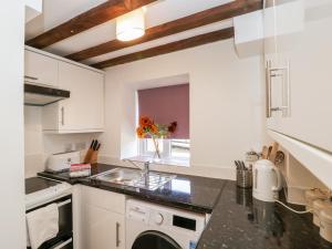 a kitchen with white cabinets and a sink at Pound Cottage in Dorchester